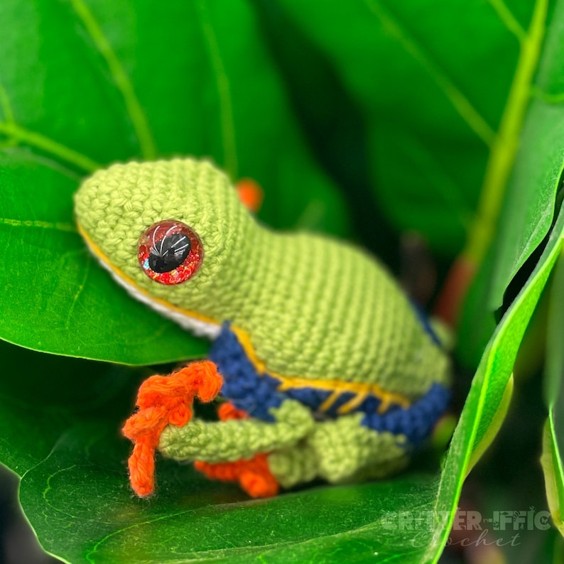 crocheted red eyed tree frog sitting in leaves looking up