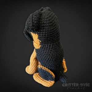 Crocheted brussels griffon dog back view looking at tail on a black background