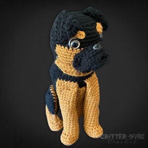 Crocheted brussels griffon dog on a black background looking right
