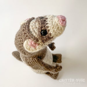 crocheted ferret from the top looking down sitting on a white background