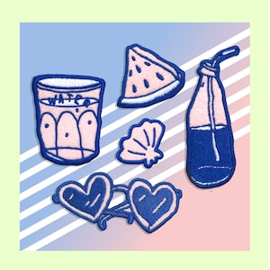 May include: A set of six embroidered iron-on patches featuring summer-themed designs. The patches are pink and blue and include a glass of water, a slice of watermelon, a seashell, a bottle of water with a straw, and a pair of heart-shaped sunglasses.