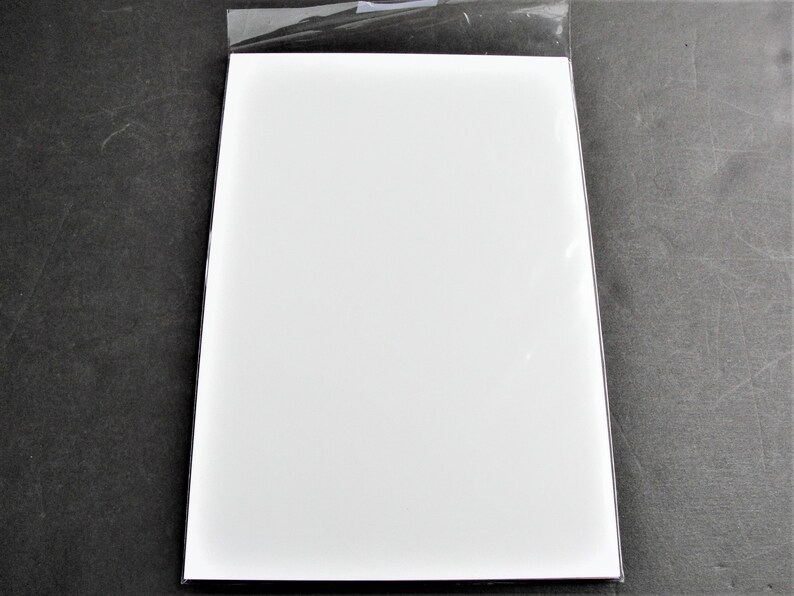 May include: A white sheet of paper in a clear plastic sleeve.