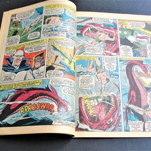 May include: A comic book page featuring a red and white monster with sharp teeth and a long tail. The monster is attacking a man in a blue and yellow costume. The text on the page reads "RROOWWR!" and "SKRAAK!"