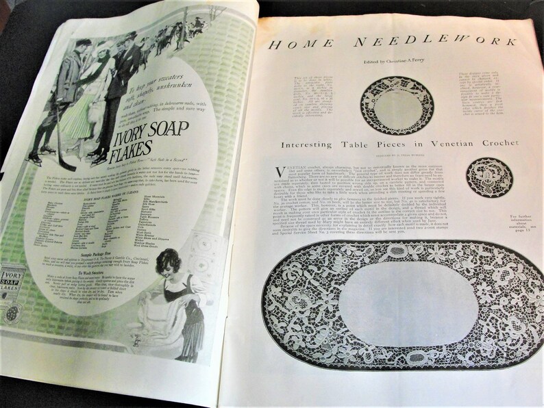 Op de afbeelding: Een tijdschriftpagina met een vintage advertentie voor Ivory Soap Flakes en een artikel over "Interessante tafelstukken in Venetiaanse haakwerk". Het artikel bevat een zwart-witte illustratie van een gehaakte ovale tafelrunner met een delicaat bloemenontwerp.