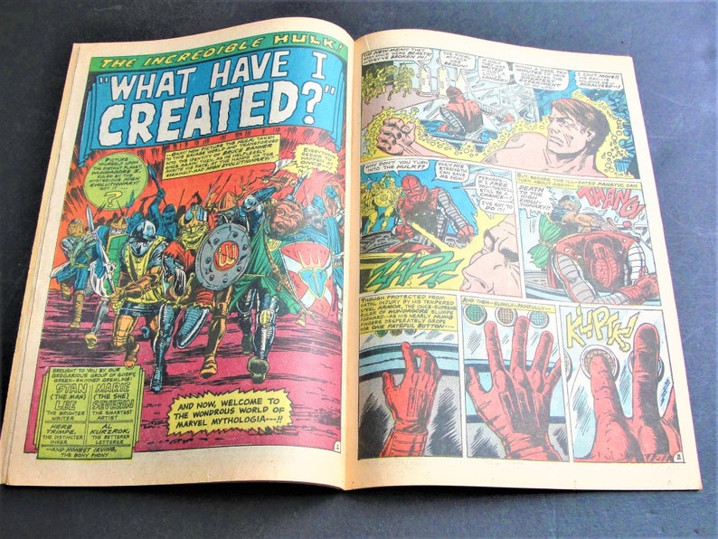 May include: A comic book cover featuring the Incredible Hulk with the text "What Have I Created?" The cover shows the Hulk in a red and yellow costume, surrounded by a group of warriors in medieval armor. The cover also includes a caption that reads "And now, welcome to the wondrous world of Marvel Mythologia---!!"