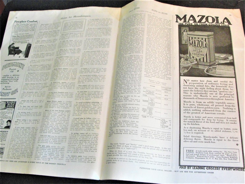 Op de afbeelding: Een vintage tijdschrift advertentie voor Mazola Ma&iuml;solie. De advertentie toont een blik Mazola Salade en Kookolie met een gestreept ontwerp. De tekst luidt "Mazola, De Pure Olie van Gouden Ma&iuml;s". De advertentie bevat ook een beschrijving van de voordelen van het product, waaronder de zuiverheid, de volledigheid en de veelzijdigheid.