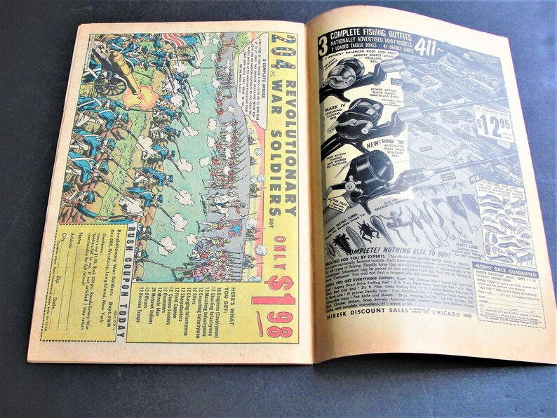 May include: A vintage comic book advertises a set of 204 Revolutionary War Soldiers for $1.98. The ad features a detailed illustration of soldiers in battle, with a red, white, and blue American flag in the background. The ad also includes a coupon for the product.