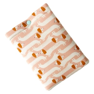May include: A rectangular, padded case featuring a repeating pattern of white dachshunds with orange ears and pink stripes. The case has a light blue button closure. The colour scheme is pink, white, and orange.