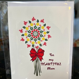 May include: A greeting card with a floral bouquet design. The bouquet features red, yellow, and white flowers, tied with a red bow. The text "For my BEAUTIFUL Mom" is printed in a burgundy color.