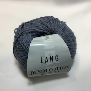 Könnte beinhalten: Eine Knäuel Lang Yarns Denim Cotton Recycled Garn in dunkelblauer Farbe. Das Etikett lautet "Lang Yarns Denim Cotton Recycled".