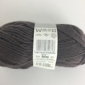 May include: A ball of dark gray yarn with a label that reads "5 015112 350818 Made in Wakefield, England by SIRDAR PLC 120yds 50g 110m approx approx In accordance with BS 984 035081 044 80% WOOL 20% NYLON 80% LAINE 20% POLYAMIDE 80% WOLLE 20% POLYAMID 80% LANA 20% POLIAMMIDICA"