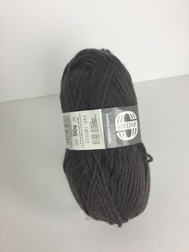 May include: A ball of dark brown yarn with a white label that reads "SIRDAR machine washable 80% WOOL 20% NYLON 50g 110m 035081 044"