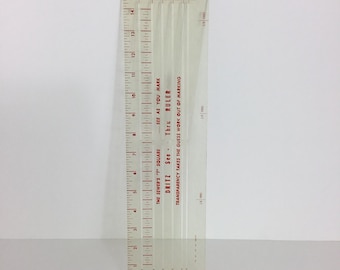 Puede incluir: Una regla de plástico transparente con marcas rojas. La regla tiene varias escalas, incluyendo pulgadas y fracciones de pulgada. El texto en la regla dice "The Sewer's 'T' Square", "See as you mark", "Dritz", "See Thru Ruler", y "Transparency takes the guess work out of marking".