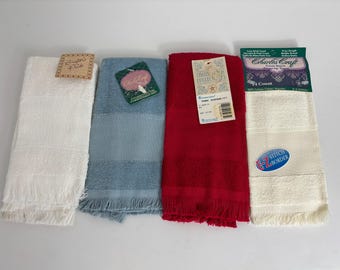 May include: Four colorful hand towels are displayed. The towels are white, blue, and red. The white towel has a fringe at the bottom and a tag that says "Southern Pride". The blue towel has a tag that says "Charleston". The red towel has a tag that says "Cross Stitch Collection". The fourth towel is white with a blue oval sticker that says "B-Z Stitch Border".