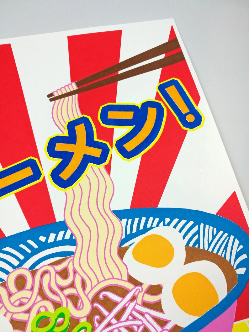 Pu&ograve; includere: Un'illustrazione colorata di una ciotola di ramen con bacchette, due uova e cipolle verdi. La ciotola &egrave; blu e bianca con uno sfondo a strisce rosso e bianco. Il testo "ラーメン!" &egrave; scritto in caratteri giapponesi.
