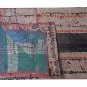 Pu&ograve; includere: Una trapunta kantha multicolore con un design a patchwork. La trapunta &egrave; realizzata in cotone e presenta una variet&agrave; di colori, tra cui blu, verde, rosa e arancione. La trapunta &egrave; piegata a met&agrave; e ha un motivo a righe sul retro.