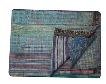 May include: A patchwork quilt made from repurposed fabric in shades of blue, green, purple, and brown. The quilt is folded in half, revealing the different layers of fabric.