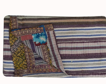 May include: A patchwork quilt with a striped pattern in shades of purple, blue, and white. The quilt features a variety of patterned fabrics, including floral and geometric designs. The quilt is folded, revealing the different patterns and textures.