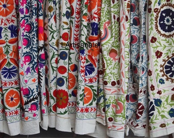 May include: A collection of colorful embroidered fabric panels with floral and geometric patterns. The panels are made of white cotton and feature intricate embroidery in shades of red, blue, green, orange, and pink.