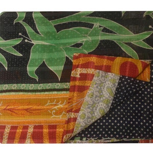 K&ouml;nnte beinhalten: Eine mehrfarbige Kantha-Steppdecke mit schwarzem Hintergrund und einem gr&uuml;nen Blumenmuster. Die Decke ist aus recycelten Saris gefertigt und ein traditionelles indisches Handwerk.