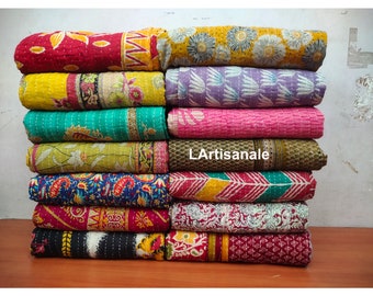 May include: A stack of 12 colorful kantha quilts with various floral and paisley patterns. The quilts are made of recycled saris and are hand-stitched. L'Artisanale is printed on the bottom of the stack.