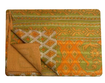 May include: A kantha quilt with a green and orange geometric pattern. The quilt is folded in half, showing the brown underside.
