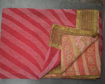 May include: A red and white striped textile with a folded section revealing a floral patterned fabric. The textile has a gold border and a brown patterned section. The overall theme is home decor.