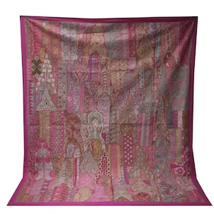May include: A large, rectangular textile with a patchwork design. The tapestry features a vibrant mix of pink, magenta, and muted earth tones. Intricate patterns and motifs adorn the fabric, creating a visually rich and detailed piece. The edges are finished with a solid magenta border.