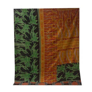 K&ouml;nnte beinhalten: Eine Patchwork-Decke mit schwarzem Hintergrund und gr&uuml;nem Blumenmuster, rotem und orangefarbenem Hintergrund mit gelbem und wei&szlig;em Muster und einem kleineren Abschnitt mit gr&uuml;nem Blumenmuster auf schwarzem Hintergrund.