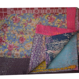 Peut inclure: Une courtepointe kantha colorée avec un motif floral. La courtepointe est faite de saris recyclés et est cousue à la main. C'est un textile indien traditionnel.