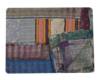 May include: A patchwork quilt with a variety of colors and textures. The quilt features rectangular patches in shades of blue, purple, green, and orange. The stitching is visible, adding to the handmade aesthetic. The quilt is rectangular.