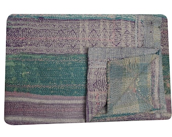 May include: A multi-colored kantha quilt with a patchwork design. The quilt is made of different fabrics sewn together in a layered pattern. The quilt is folded in half and has a rustic, vintage look.