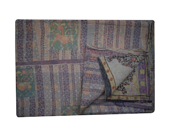 May include: A multi-colored kantha quilt with a patchwork design. The quilt is made of recycled saris and features a variety of floral and geometric patterns. The quilt is folded in half and shows the different layers of fabric.