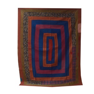 Pode incluir: Uma colcha colorida com um padr&atilde;o de quadrados conc&ecirc;ntricos. A colcha tem um centro azul escuro rodeado por quadrados vermelhos, rosa e laranja. A borda exterior &eacute; um padr&atilde;o floral verde escuro e marrom.
