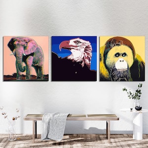 May include: Three colorful pop art style prints featuring a pink elephant, a blue and white bald eagle, and a yellow orangutan.