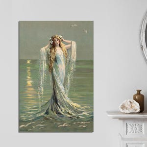 May include: A woman with long blonde hair wearing a flowing white dress stands in the ocean. The water is a light blue and green colour, and the sky is a light blue. The woman is looking to the right, and her hair is flowing in the wind.