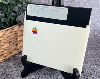 May include: A white Apple II floppy disk with a black label that reads "EDUCATIONAL TECHNOLOGY PROGRAM Cat. No. 29539 (Diskette) ETP Apple 86 01 Sequencing". The disk is in a white plastic case with a black stand.