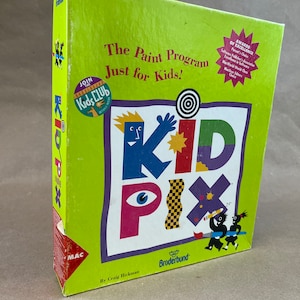 May include: A green box with a colorful illustration of a cartoon character holding a paintbrush. The box is for a computer program called Kid Pix, The Paint Program Just for Kids! by Broderbund. The box has a Mac logo and mentions that it is a Kids Club Edition.