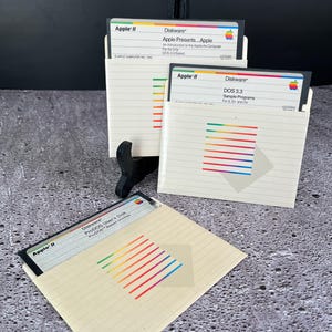 May include: Three Apple II floppy disks with colourful rainbow stripes. The disks are labelled "Diskware" and include titles such as "Apple Presents... Apple", "DOS 3.3 Sample Programs", and "ProDOS User's Disk".