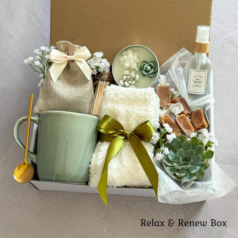 Pu&ograve; includere: Una confezione regalo con l'etichetta Relax & Renew Box contenente una tazza in ceramica verde salvia con cucchiaio dorato, un sacchetto di juta con nastro color crema, una candela a forma di succulenta, un asciugamano bianco e un nastro verde.