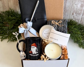 Può includere: Una confezione regalo contenente un taccuino nero con penna argentata, una tazza nera con grafica di un fantasma, un cucchiaio argentato, una candela profumata in barattolo, un sacchetto di sali da bagno, calzini in maglia grigia e cubetti color caramello.
