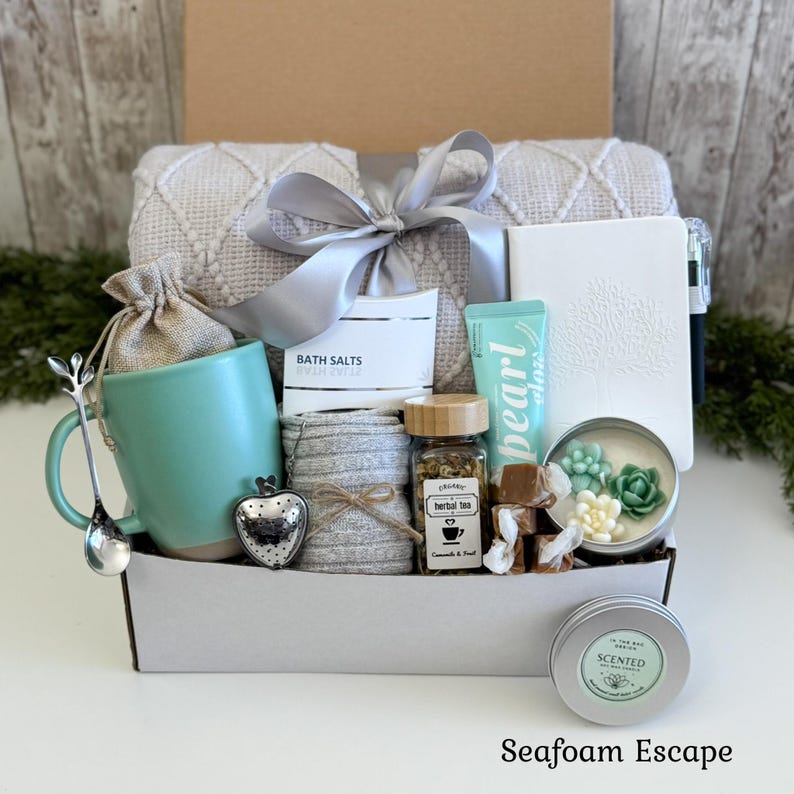 Pu&ograve; includere: Una confezione regalo contenente una tazza verde chiaro, un infusore per t&egrave; a forma di cuore, un cucchiaio, una coperta in maglia grigia con nastro argento, sali da bagno, un diario bianco, crema Pearl Glow, tisana e una candela.