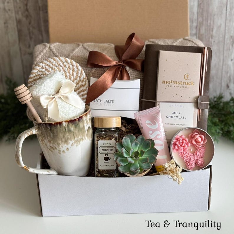 Pu&ograve; includere: Una confezione regalo contenente una tazza in ceramica con spargimiele, un barattolo di tisana, una pianta grassa, una tavoletta di cioccolato al latte Moonstruck, un tubetto alla rosa, una candela con decorazioni in cera rosa e una coperta.