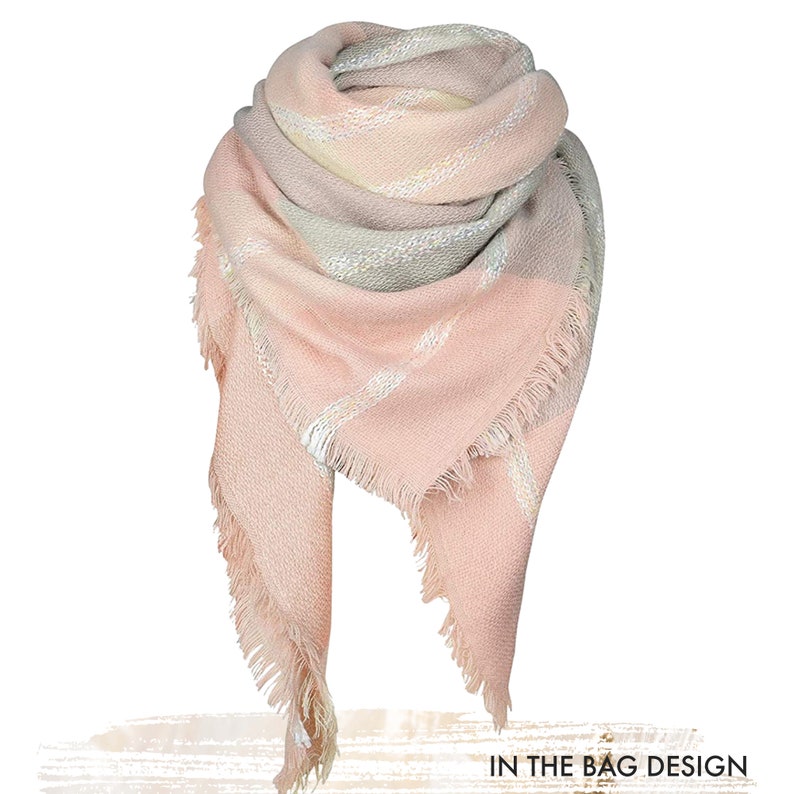 May include: A triangular scarf featuring a soft pastel color palette of blush pink, cream, and light grey. The fabric displays a woven texture with diagonal striped patterns and finished with frayed edges. The text IN THE BAG DESIGN is visible.
