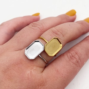 May include: Two adjustable rings with octagonal shaped bezels. One bezel is gold and the other is silver.