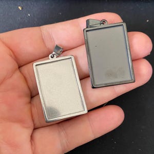 10/50 unidades de colgantes rectangulares con engaste de cabujones de acero inoxidable negro, tamaño interior de 20 x 30 mm.
