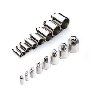 May include: Assortment of silver metal end caps for jewellery making. The caps are in various sizes and have a loop at the top for attaching to a cord or chain.