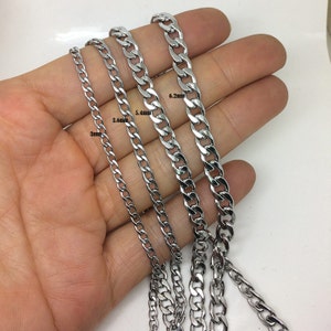 Pode incluir: Quatro correntes de curb prateadas de diferentes larguras, dispostas sobre uma mão. As correntes medem 3 mm, 3,6 mm, 5,4 mm e 6,2 mm.