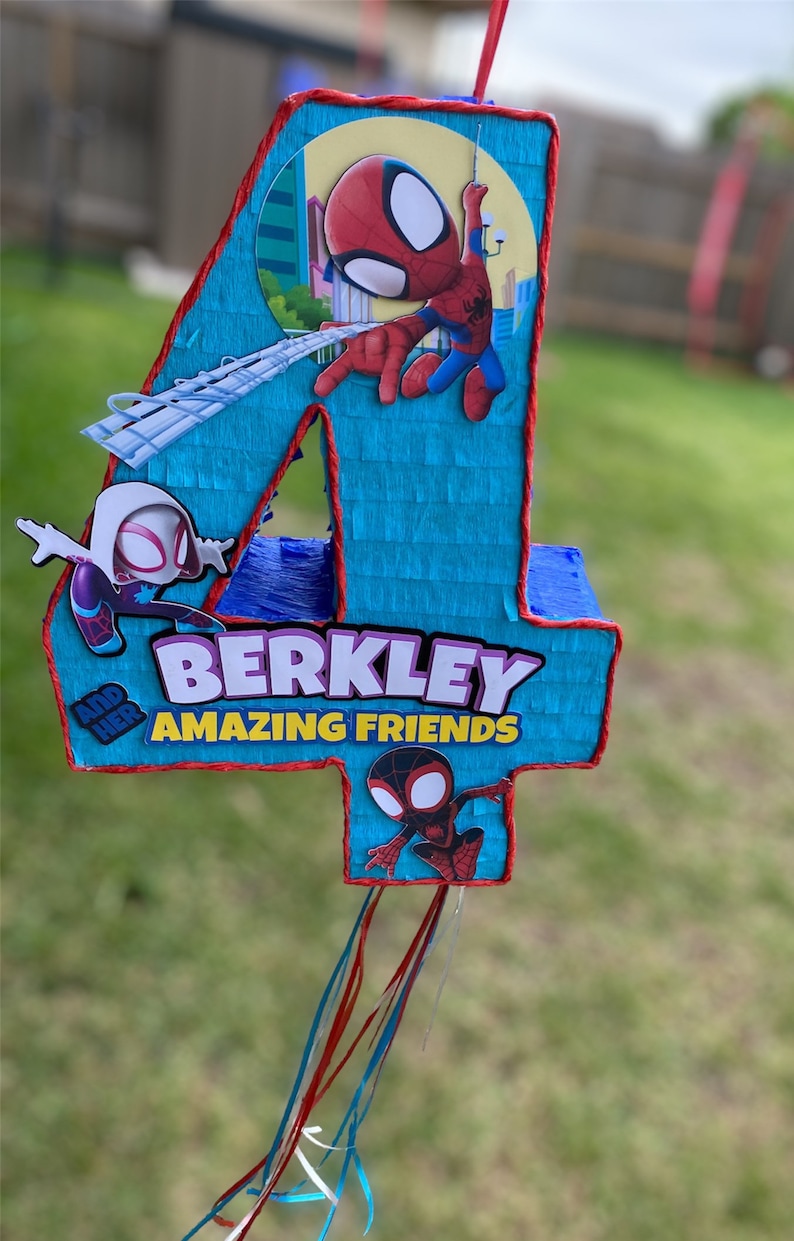 Może przedstawiać: Niebiesko-czerwona pi&ntilde;ata w kształcie cyfry cztery z postaciami Spidermana. Pi&ntilde;ata ma napis "Berkley and her Amazing Friends".