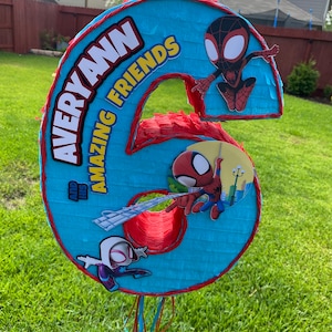Może przedstawiać: Niebiesko-czerwona pi&ntilde;ata w kształcie sz&oacute;stki z motywem Spidermana. Na g&oacute;rze znajduje się napis "Averyann and His Amazing Friends".